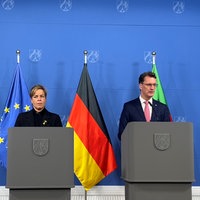 Mona Neubaur und Hendrik Wüst stehen nebeneinander vor Redepulten und geben eine Pressekonferenz