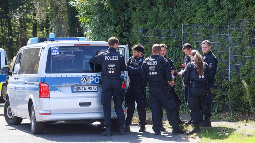Polizeiteam vor einem Polizeiwagen