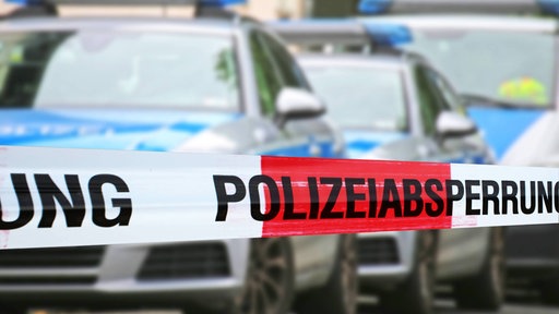 Polizeiabsperrung mit mehreren Polizeiautos im Hintergrund