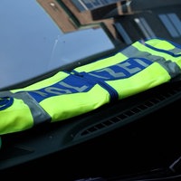 Eine Polizeiweste liegt auf der Amatur eines Polizeiwagens