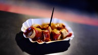 Currywurst aufgeschnitten mit Currysauce in einer typischen Imbissbuden-Schale