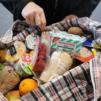 Eine Person zeigt ihre Tasche mit gespendeten Lebensmitteln