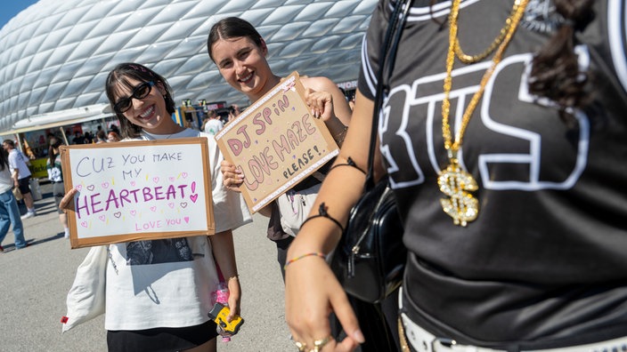 Vor der Allianz Arena warten die Fans der K-Pop Gruppe BTS Ines (li.) und Clara aus der Schweiz mit Schildern. Die Band gibt ihre zwei einzigen Konzerte in Deutschland in München.