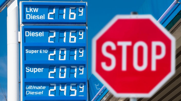 Vor den hohen Spritpreisen für Benzin und Diesel steht ein Stopschild als Symbolbild für eine Benzinpreisbremse