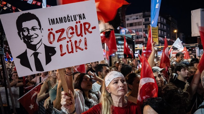 Eine Frau hält ein Plakat mit der Aufschrift „Freiheit für Ekrem Imamoglu“. 