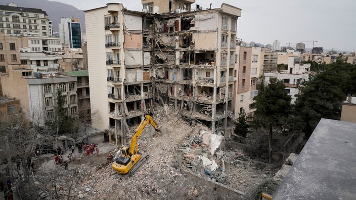 Rettungskräfte des iranischen Roten Halbmonds räumen mit einem Bulldozer die Trümmer eines Wohnhauses weg, das bei einem früheren amerikanisch-israelischen Angriff getroffen wurde. 
