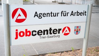 Arbeitslose stehen Schlange bei der Bundesagentur für Arbeit