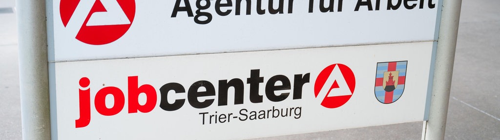 Arbeitslose stehen Schlange bei der Bundesagentur für Arbeit