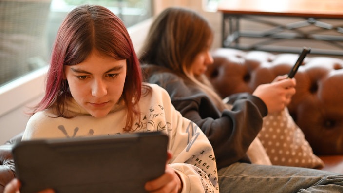 Zwei jugendliche Mädchen beschäftigen sich mit Social Media auf ihren IPads