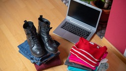 Dve gomile second hand odeće i obuće i laptop