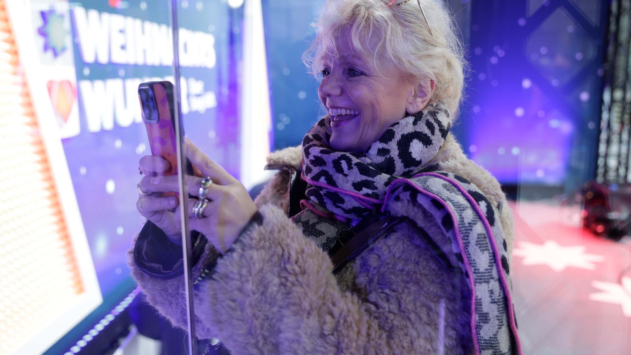 Das WDR 2 Weihnachtswunder am Sonntag (14.12.2025) - Eine Besucherin macht ein Foto vor dem Glashaus.