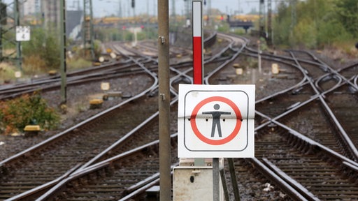 Ein Schild mit einem Symbol für "Nicht betreten" vor leeren Gleisanlagen