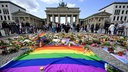 Am Brandenburger Tor in Berlin liegen rund um eine Regenbogenflagge Blumen und Kerzen nach dem tödlichen Anschlag beim CSD am 25.07.27 (Foto vom 27.07.2026)