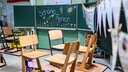 Hochgestellte Stühle und eine bemalte Tafel und den Worten "Schöne Ferien" im Klassenraum einer Schule (Archivfoto vom 23.07.2025)