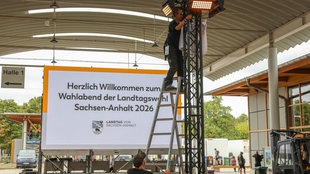In Magdeburg bauen Mitarbeiter eine Videoleinwand vor den Messehallen zur Landtagswahl 2026 in Sachsen-Anhalt auf.