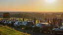 An der Lacher Straße in Solingen stehen Menschen am Mittwochabend (12.08.2026) neben dicht an dicht parkenden Autos - von der exponierten Lage aus ließ sich die Sonnenfinsternis besonders gut beobachten.