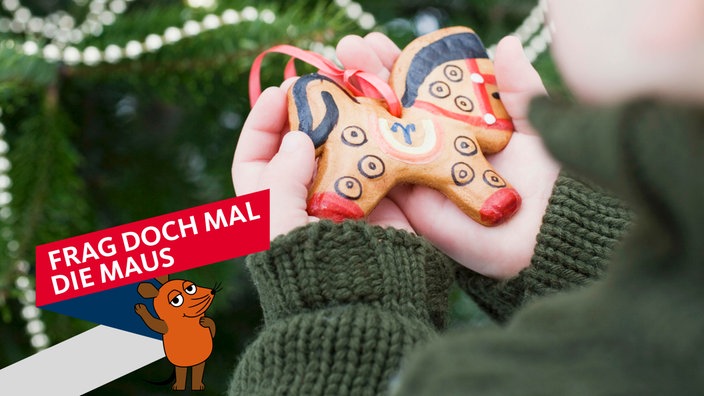 Ein Kind hält ein Honigkuchenpferd in der Hand