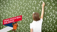 Mädchen schreibt mit Kreide Fragezeichen auf eine Schultafel