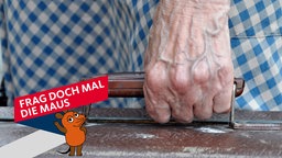 Die Hand einer Frau trägt einen alten Koffer - die Adern auf dem Handrücken treten deutlich sichtbar bläulich hervor