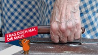 Die Hand einer Frau trägt einen alten Koffer - die Adern auf dem Handrücken treten deutlich sichtbar bläulich hervor