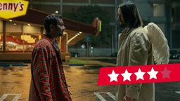 Aziz Ansari und Keanu Reeves stehen in einer Szene aus "Good Fortune - Ein ganz spezieller Schutzengel" im Dunkeln auf einem Parkplatz