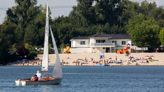 Ein Segelboote auf dem Liblarer See, im Hintergrund das Strandbad