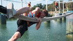 Aqua-Climb in Selm: Ein junger Mann zieht sich an einer Slckline hoch