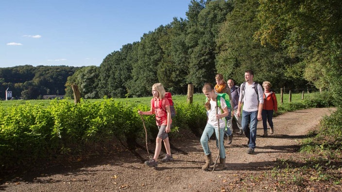 Personen unterschiedlichen Alters unterwegs auf einem Wanderweg