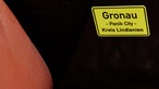 Ein Aufkleber mit der Aufschrift "Gronau - Panik City - Kreis Lindianien" auf der Couch im Hotelzimmer aus Hamburg in der Sonderausstellung "Udo L. wohnt im Hotel - Exklusive Einblicke in meine Panikzentrale" im Rock'n'Popmuseum in Gronau.