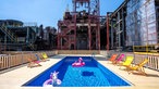Im Becken des Werksschwimmbads auf Zollverein schwimmen aufblasbare Gummitiere, drumherum die alte Industriekulisse