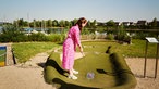 Eine Frau spielt Minigolf im Freizeitpark Xanten
