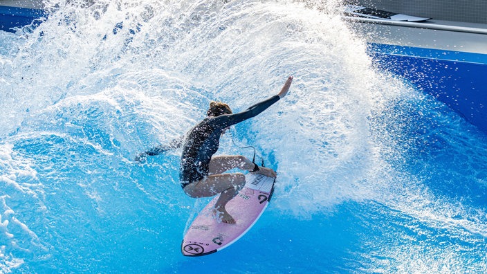 Eine Surferin surft im RheinRiff