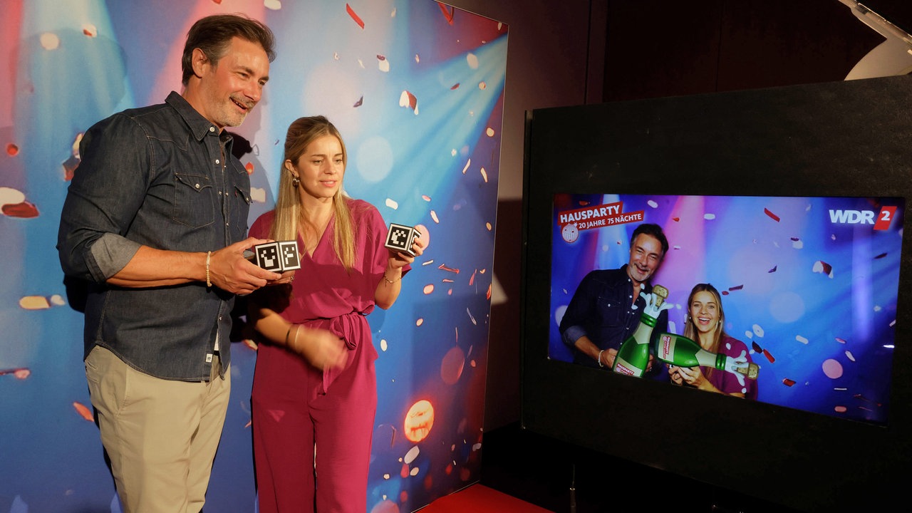 Marco Schreyl und Michelle Fausten testen die WDR 2 Fotobox bei der Hausparty in Siegburg