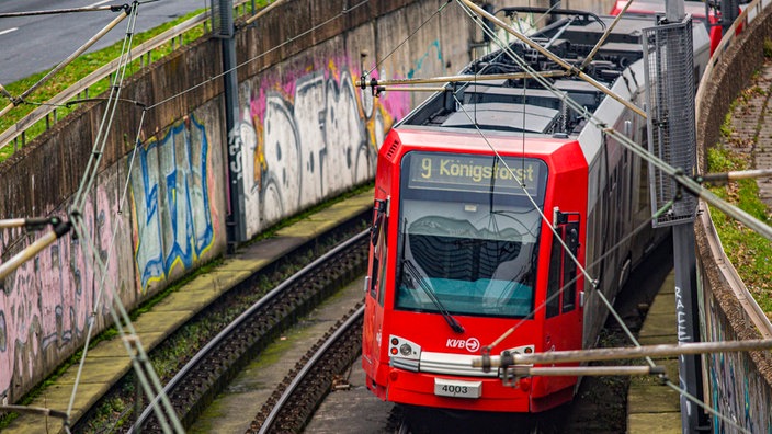 Bahn der Linie 9 an der Haltestelle Deutzer Freiheit, an die Wänden des Bahnschachts sind Graffitis gesprüht.