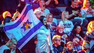 Musikfans der Teilnehmerin aus Israel stehen am 15.05.2025 mit der israelischen Fahne vor dem zweiten Halbfinale des 69. Eurovision Song Contests im Publikum in der St. Jakobshalle im schweizerischen Basel. 