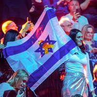 Musikfans der Teilnehmerin aus Israel stehen am 15.05.2025 mit der israelischen Fahne vor dem zweiten Halbfinale des 69. Eurovision Song Contests im Publikum in der St. Jakobshalle im schweizerischen Basel. 