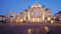 Das Theater Osnabrück und der Vorplatz bei Abenddämmerung.