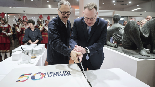 Zwei Männer schneiden am am 13. September 2026 eine Torte an mit der Aufschrift: 50 Jahre Museum Ludwig 