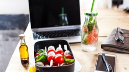 Symbolbild Pause am Schreibtisch: eine Lunchbox mit einem Laptop