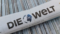 Eine zusammengerollte Tageszeitung von "Die Welt".