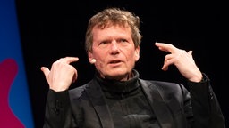 Hartmut Rosa gestikuliert mit beiden Händen.