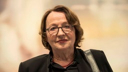Schrifstellerin Katja Lange-Müller blickt vor orangem Hintergrund in die Kamera