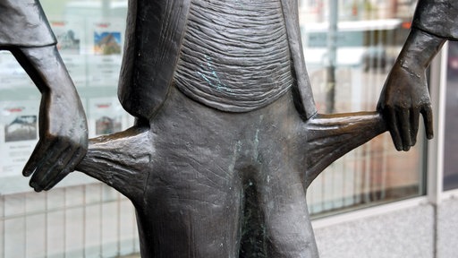 Symbolbild: Auschnitt einer Statue, deren Hände die leeren Hosentaschen nach außen stülpen.