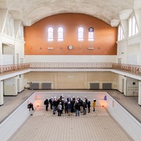 Archivaufnahme von 2019: Innenansicht des Krefeldes Stadtbads, in dessen leerem Schwimmbecken ein Menschengruppe steht.
