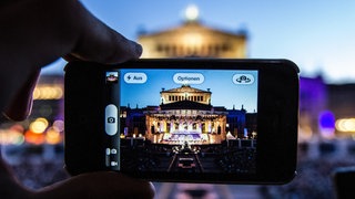 Ein Mann fotografiert am 06.07.2013 beim Classic Open Air auf dem Gendarmenmarkt in Berlin.