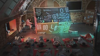Kinder und Jugendliche liegen auf roten Matten vor der "Soundmachine" des Künstler-Kollektiv "Art Helps".