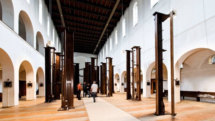 Installation von Dorothee Bielfeld in Christ-König-Kirche Bochum, 2010: Senkrecht aufgestellte Kirchenbänke.