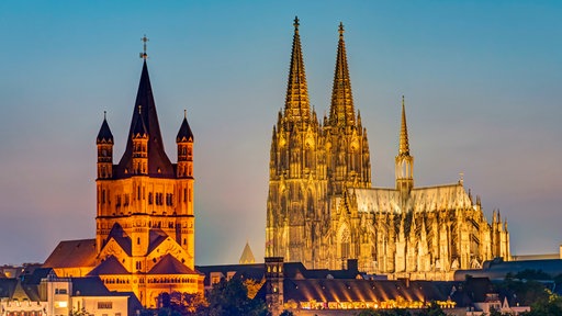 Der Kölner Dom und die Kirche Groß St. Martin nach Sonnenuntergang.