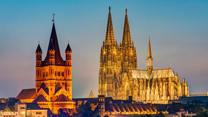 Der Kölner Dom und die Kirche Groß St. Martin nach Sonnenuntergang.