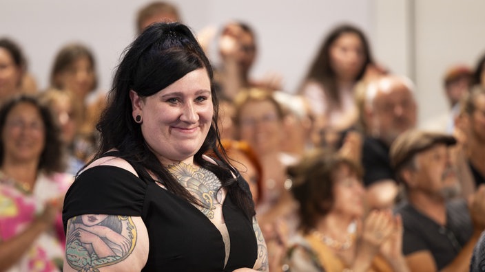 Lena Schätte steht bei der Preisverleihung im Rahmen der Tage der deutschsprachigen Literatur in Klagenfurt im Studio, umgeben von Publikum. 